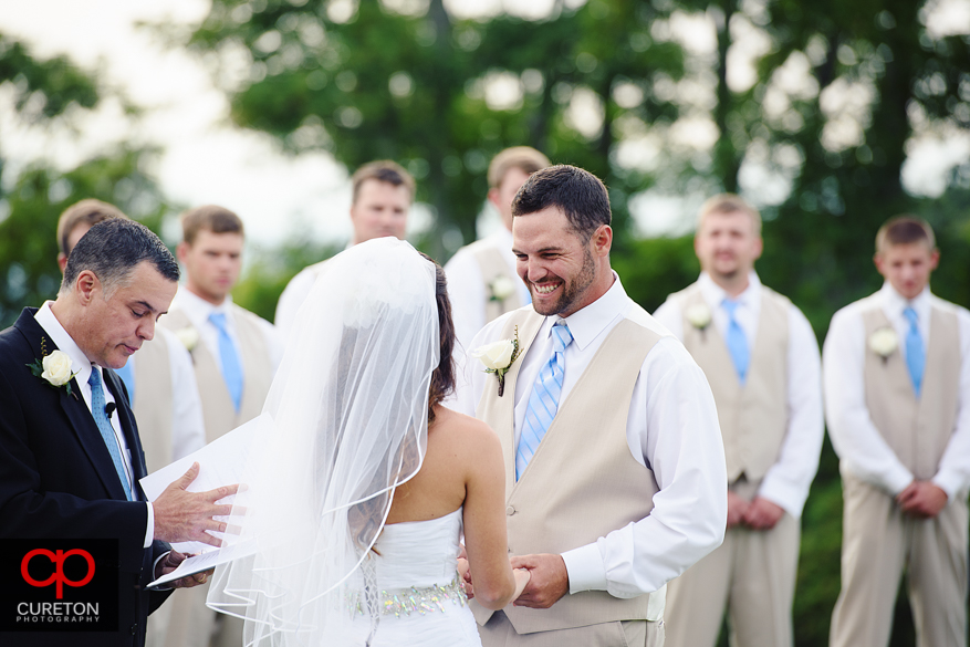 The groom smiling at his bride during the ceremony.