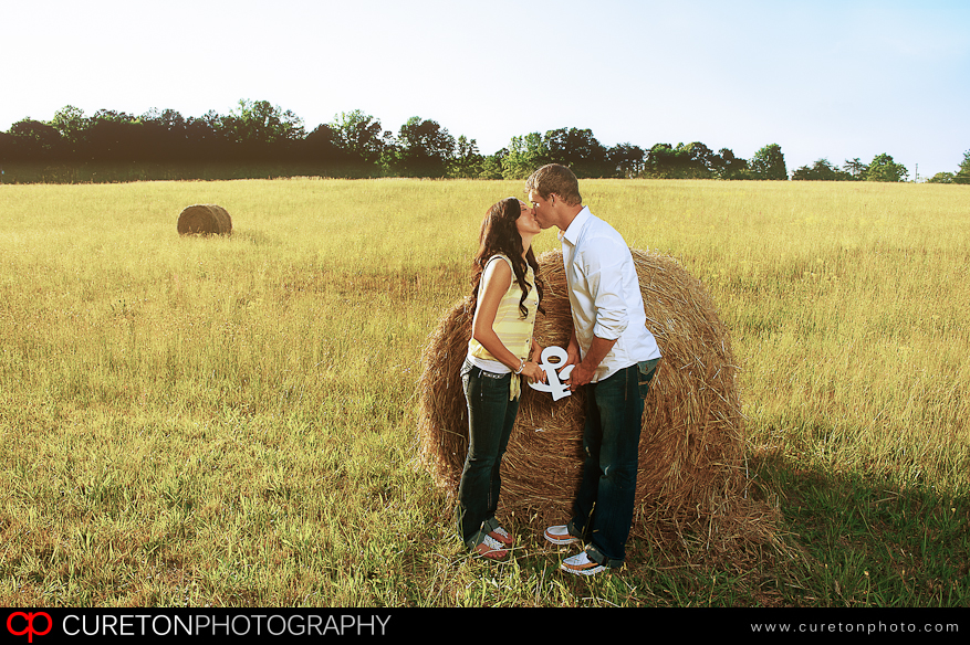 A couple in front of a hay bale at a Greenville farm.