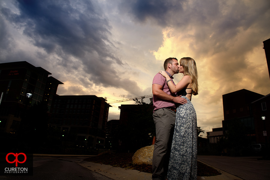 Couple kissing at sunset during a downtown Greenville engagement session.