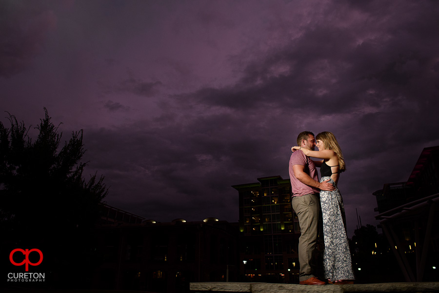 Engaged couple dancing under purple skies in downtown Greenville,SC.