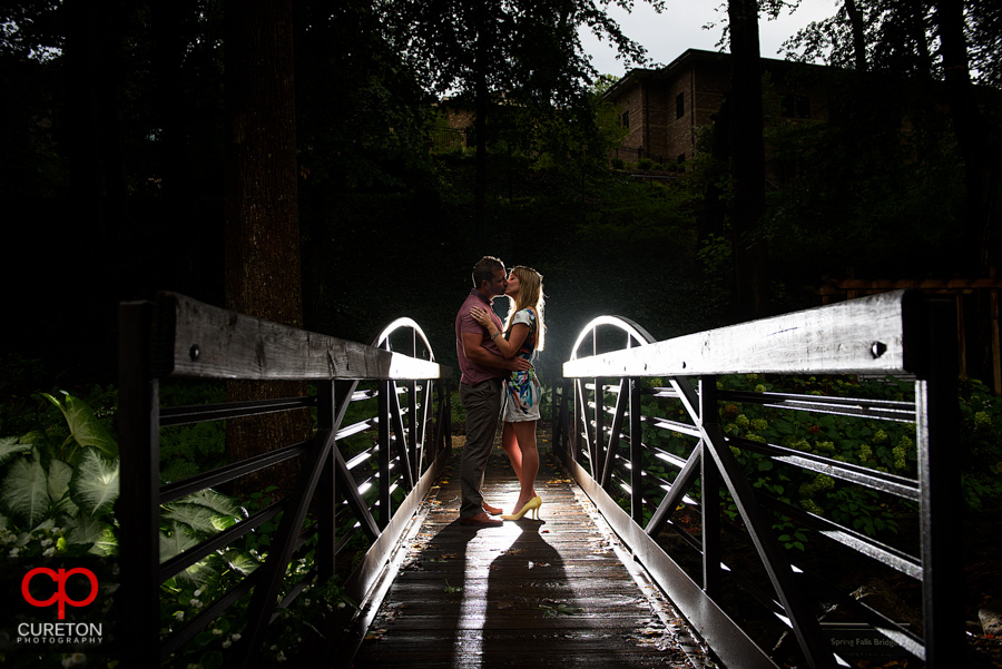 Couple walking across a small bridge in the park.