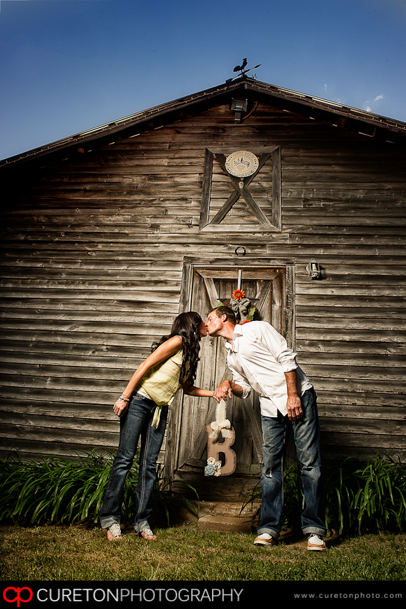 A couple kissing in front of a barn at a farm outside Greenville,SC