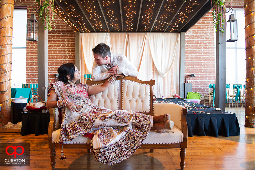 Bride and groom sit on a couch before their wedding.