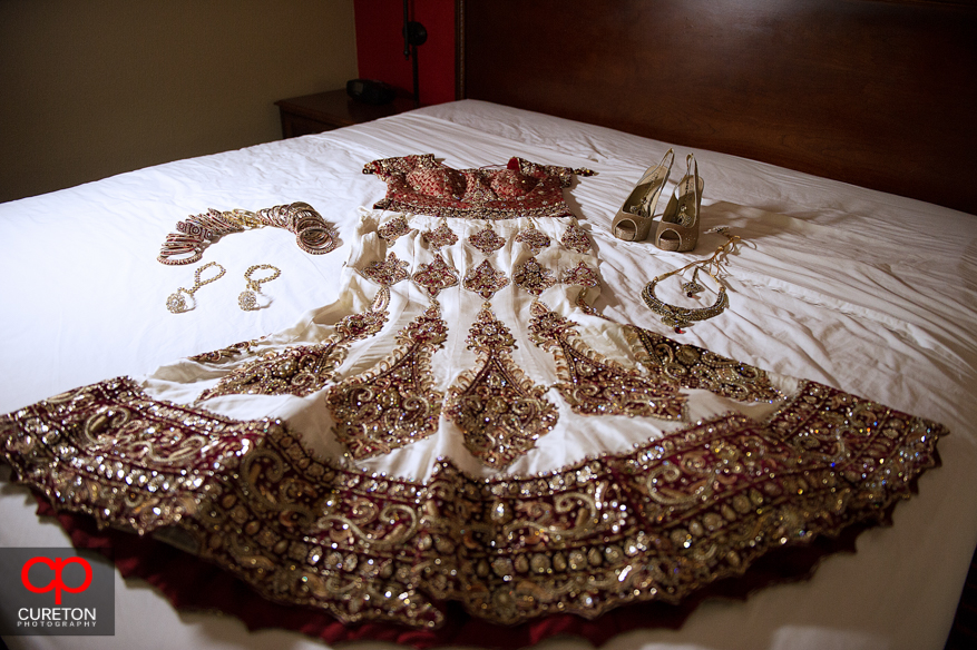 Indian bridal dress laid on a bed/