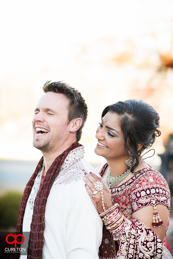 Groom laughing with bride during their first look.