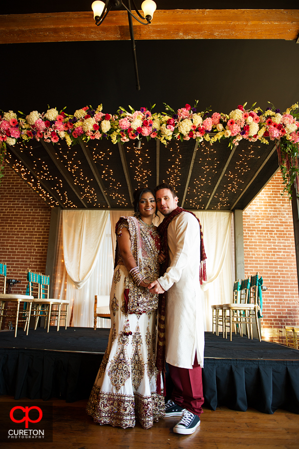 Groom and bride stand under the mandap their Indian wedding in Greenville,SC..