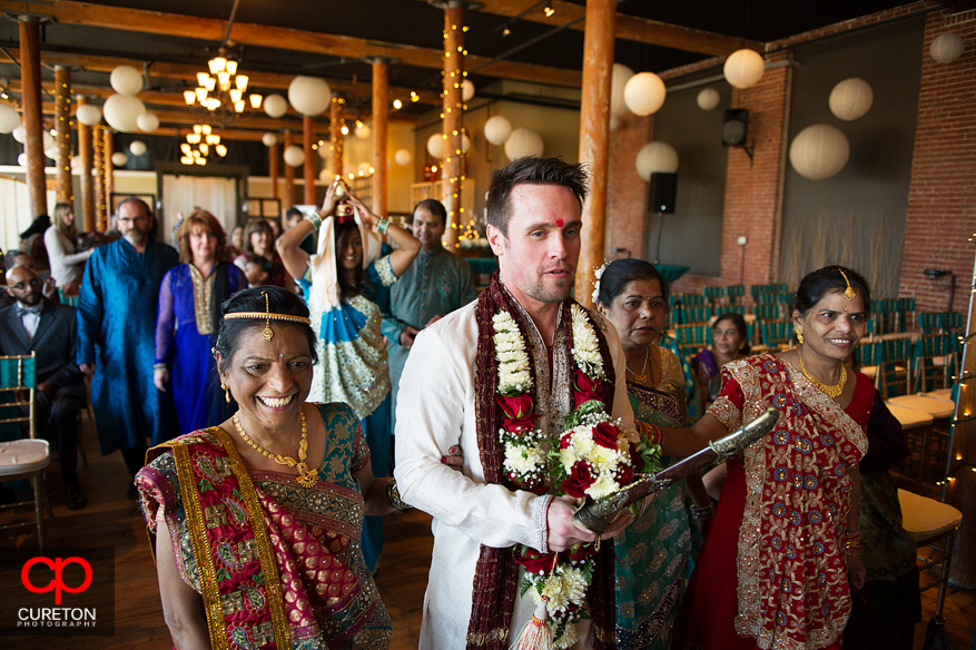 Bride's mother leads the groom to the mandap