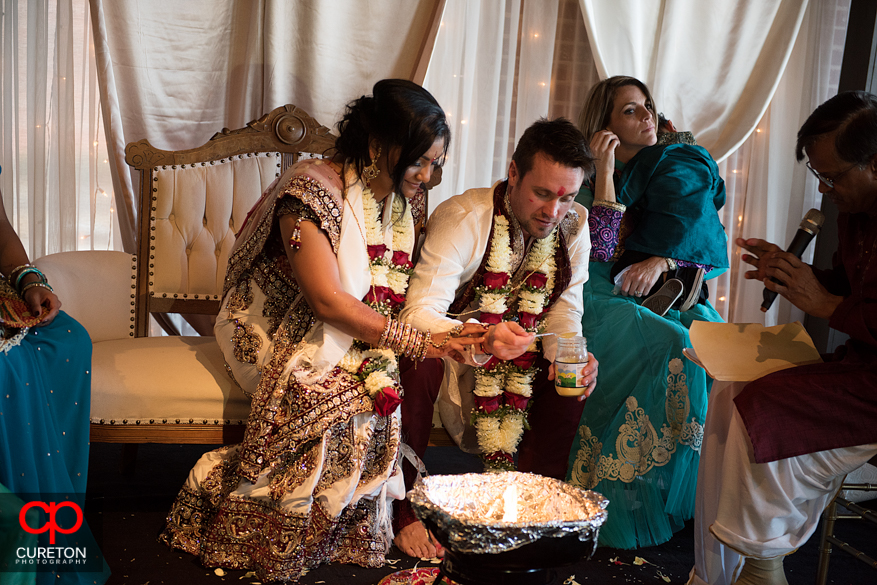 Bride and groom put items in the fire their Indian wedding in Greenville,SC..