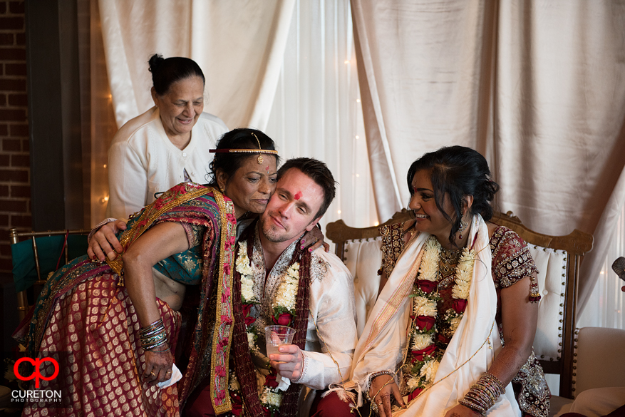 Brides mother hugs the groom during the wedding ceremony.