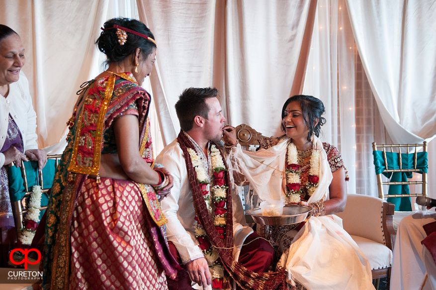 Bride feeds groom during the traditional Indian ceremony.