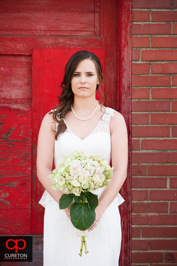 Bride in front of red door.