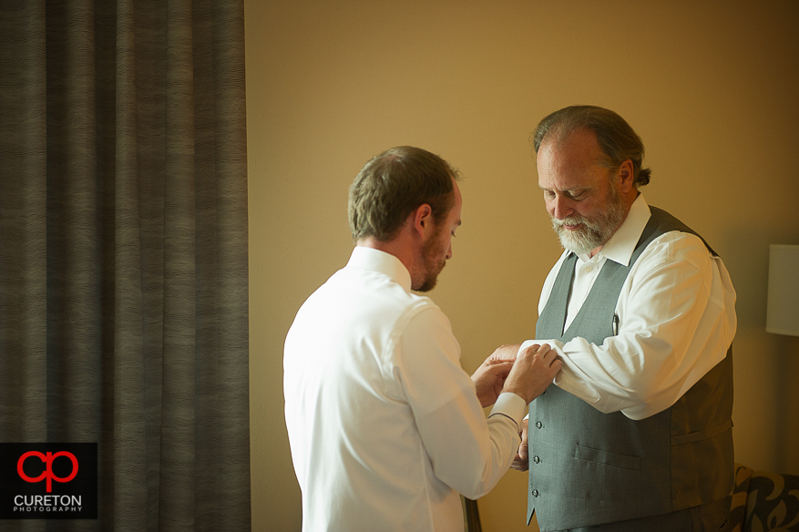 Groom helping his father get dressed.