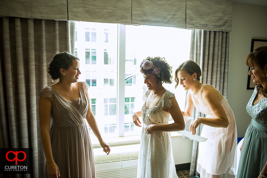 Bride putting on her dress before her wedding in downtown Greennville,SC.