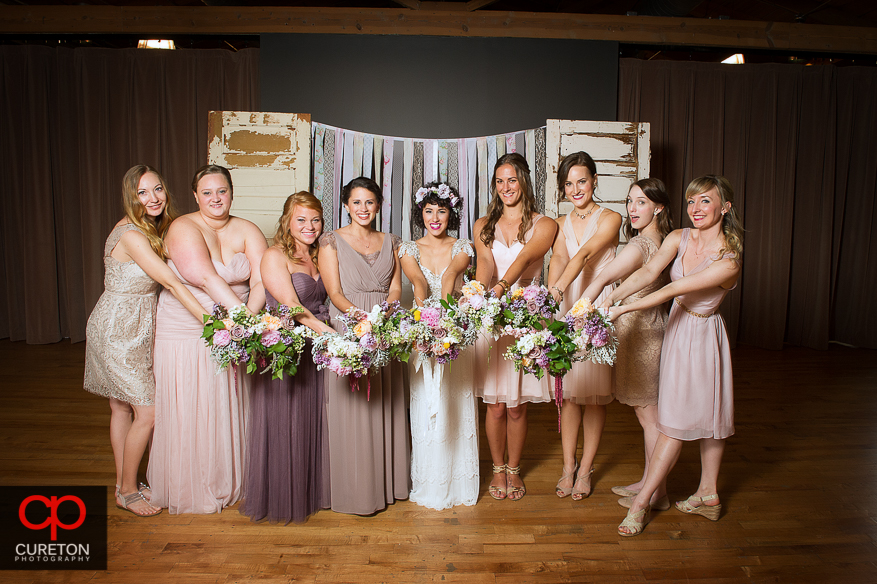 Bridesmaids holding flowers out.