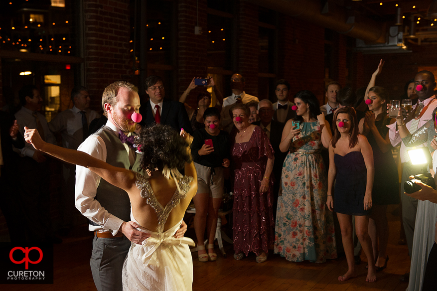 Bride and Groom dancing with red noses.