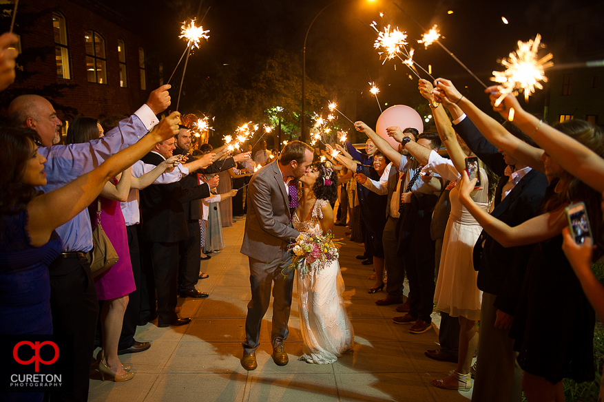 Bride and groom leave the Certus loft through sparklers.