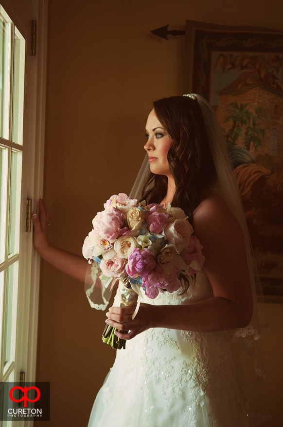 The bride staring out the window before hew wedding.