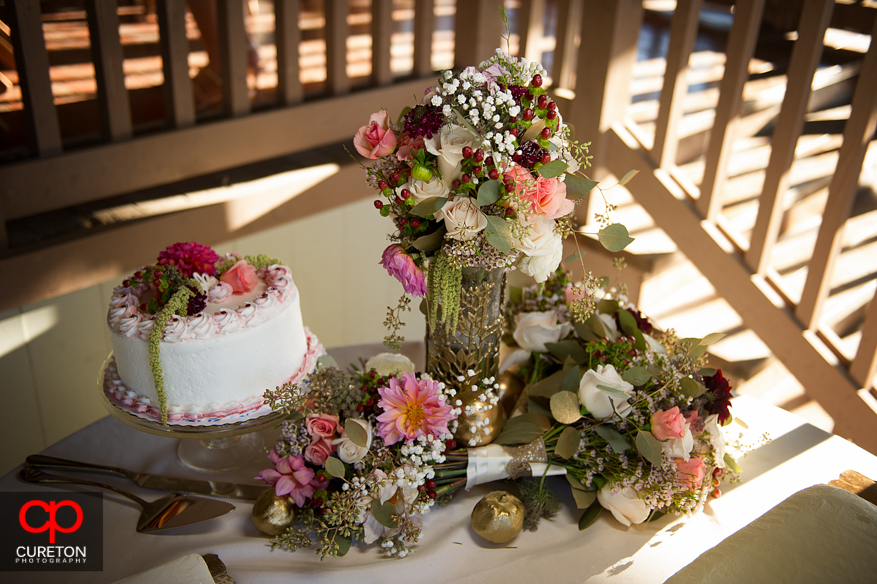 Awesome floral arrangement next to the wedding cake.