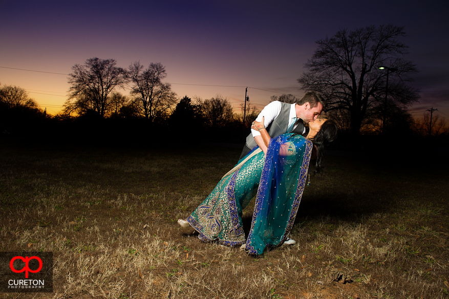 Groom dipping the bride at sunset outside the Loom in Simpsonville after their wedding.