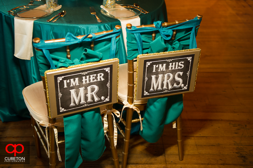 Mr. and Mrs. sign for wedding reception seats.