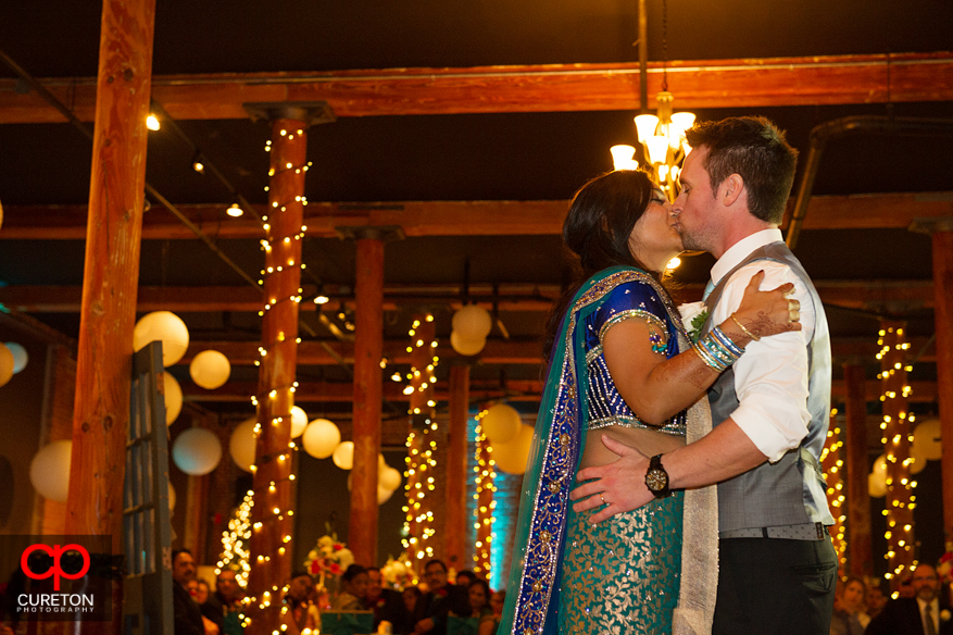 Married couple kissing after their first dance.