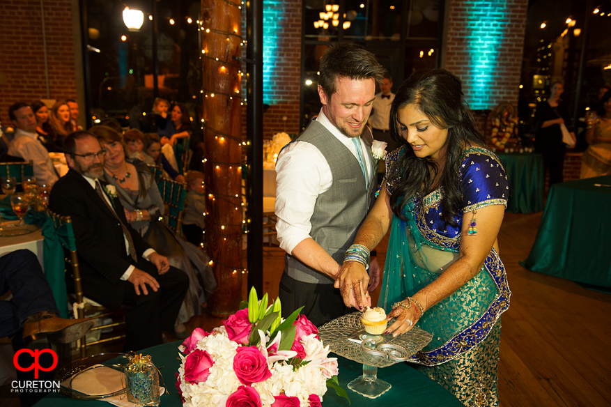 Bride and Groom cutting the cake at their Indian wedding reception.