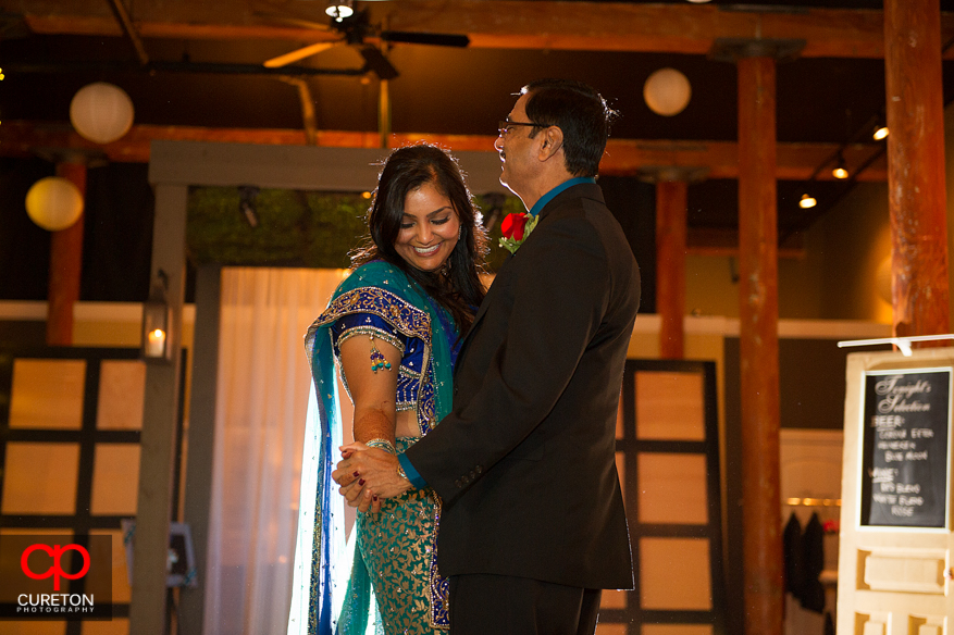 Bride laughing during father-daughter dance.