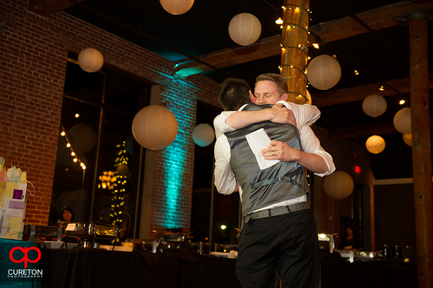 Groom and his brother hugging after the toast.