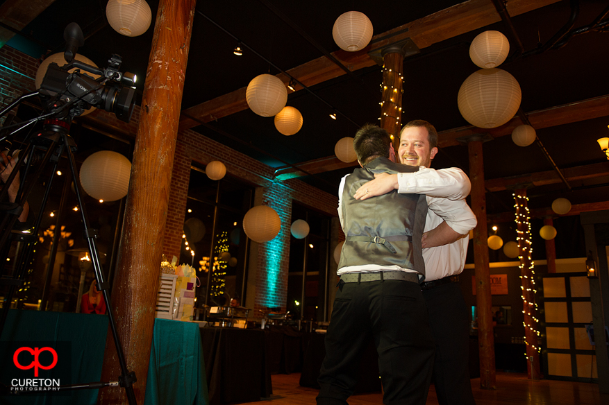 Groom giving a friend a hug after the toast.