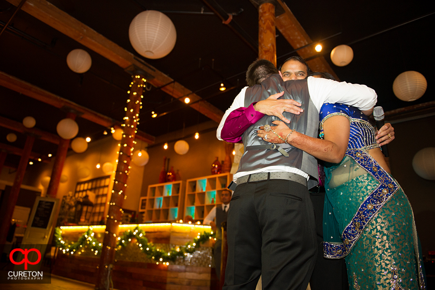 Bride and Groom hug her cousin.