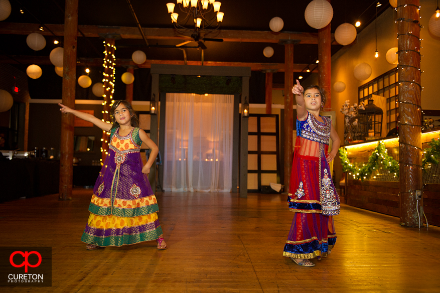 Flower girls dancing at an Indian wedding reception.