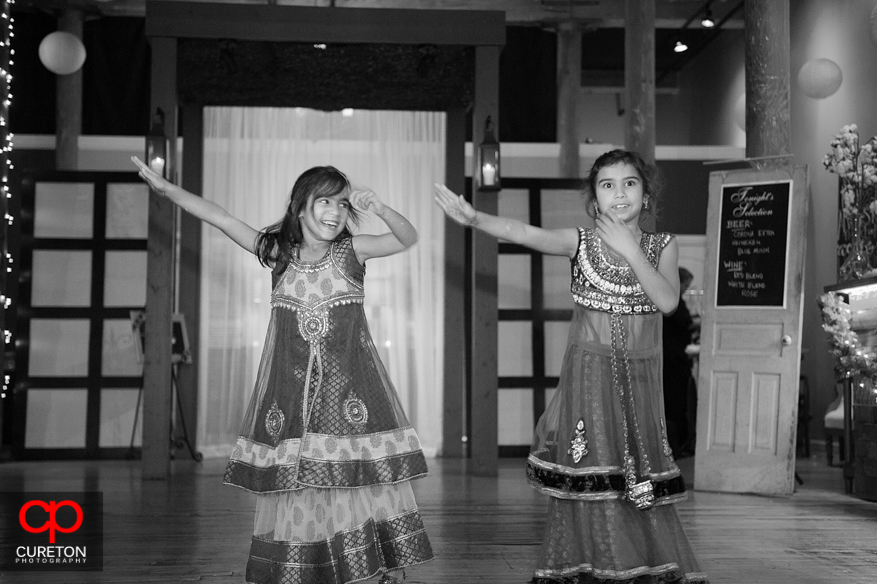 Flower girls dancing for the bride and groom.