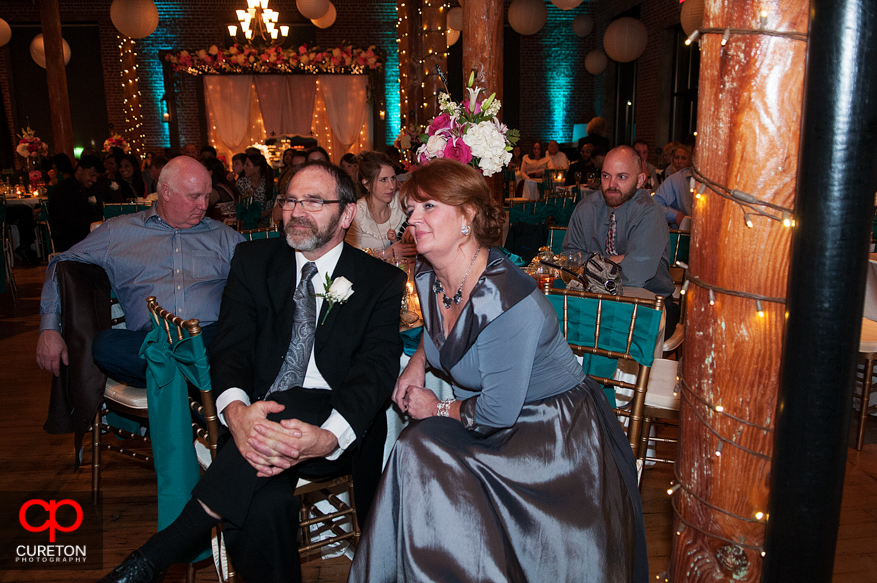 Grooms parents look on at the wedding performances.