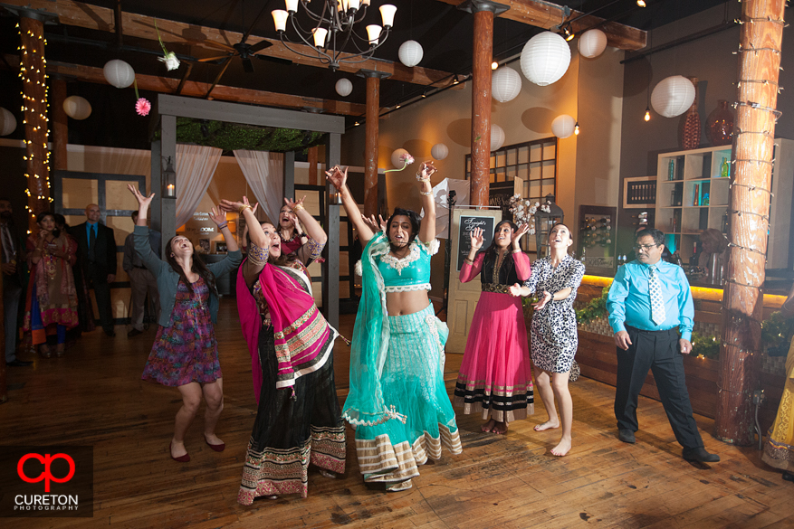 Bridal party trying to catch the flowers.