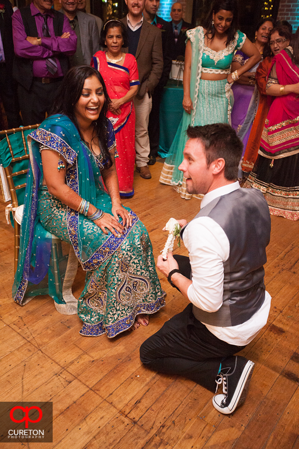 Groom taking off the bride's garter.