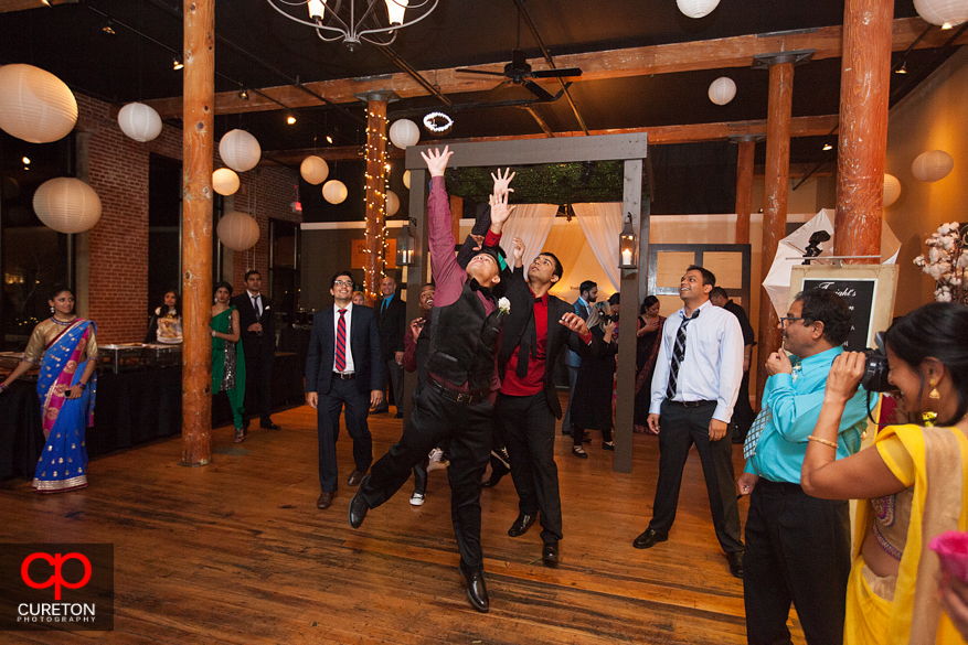 Groomsmen and guest catching the garter.