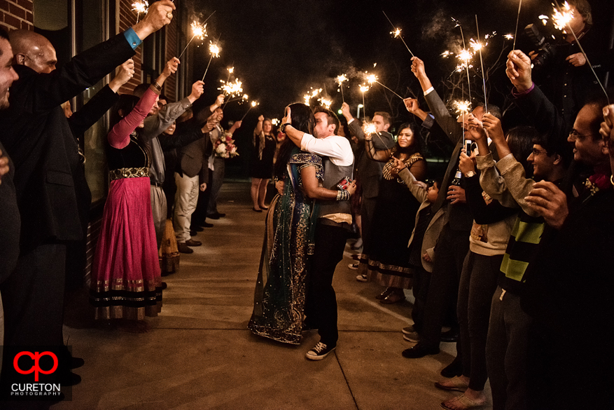 Brie and groom kissing under sparklers at The Loom.