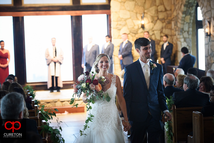 The bride and groom leaving the chapel at the Cliffs at Glassy.