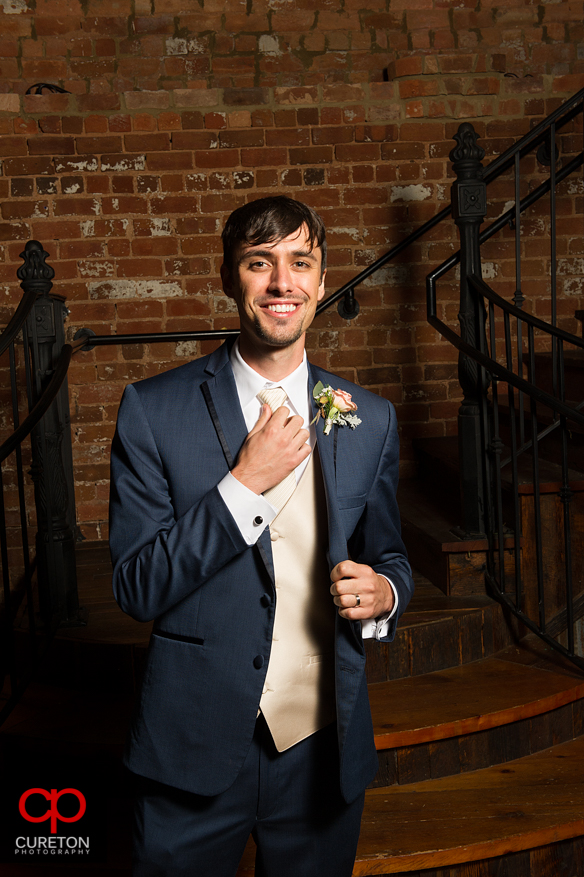 The groom straightening his tie.