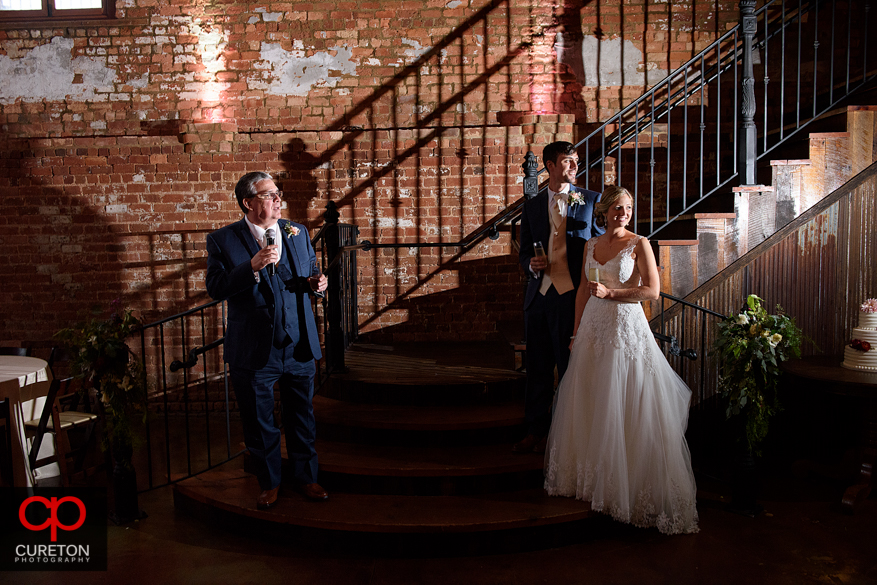 Bride and groom listed to toasts at the reception.