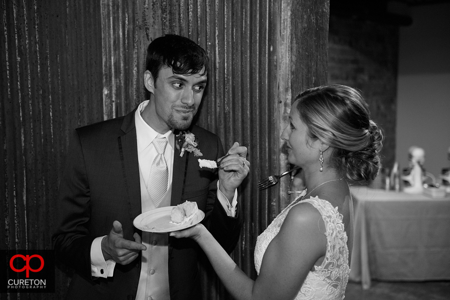 Groom feeding the bride cake.