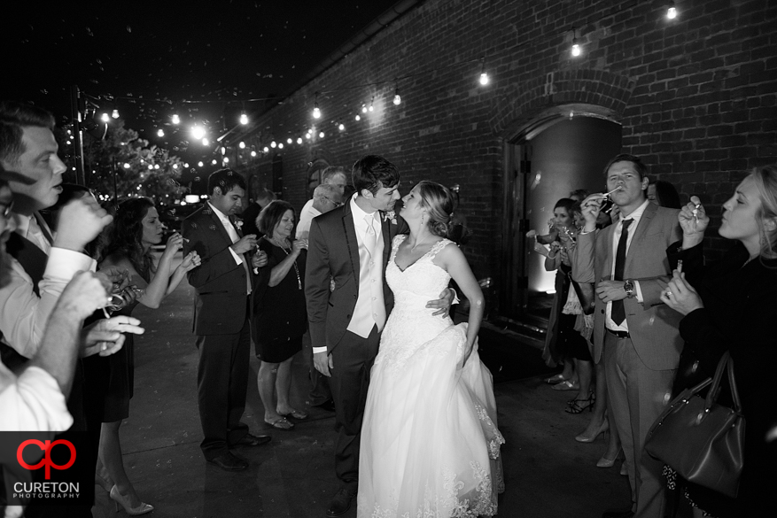 Couple kissing while leaving their wedding.