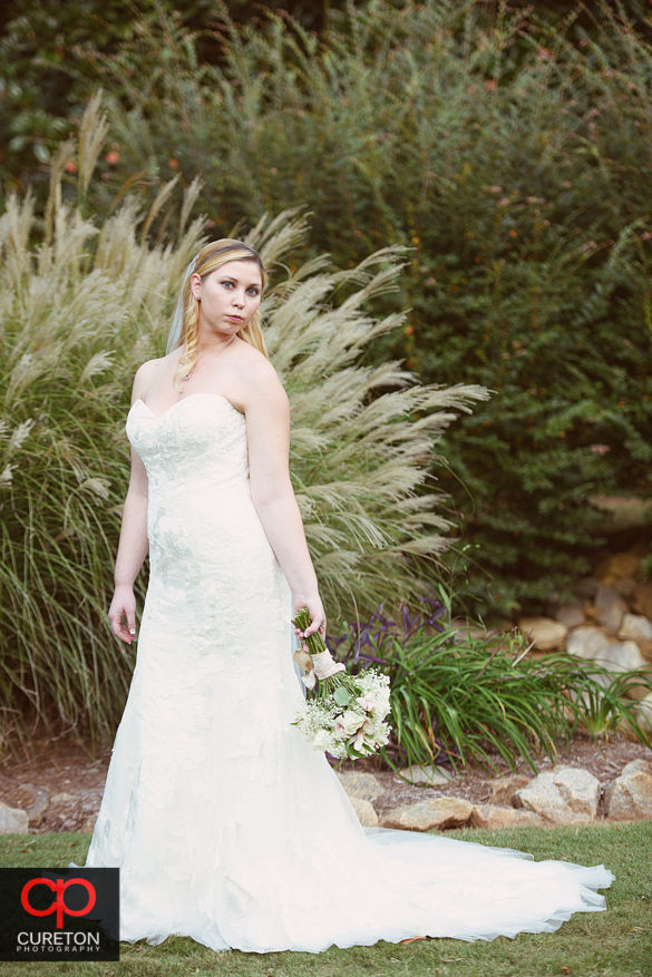 Bride standing in front of pampers grass.