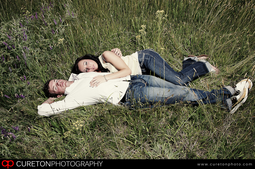 Bride laying on a groom at a rustic outdoor location.