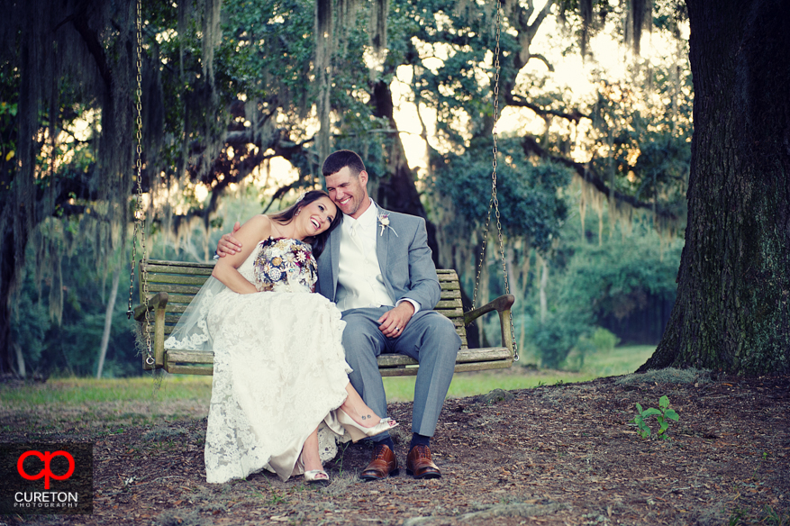 Bride with her head on grooms shoulder on swing.