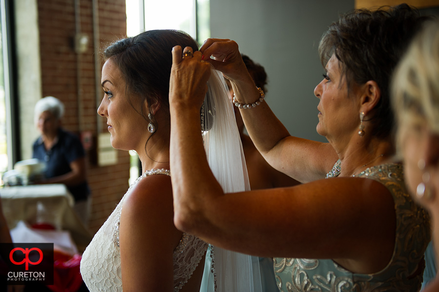 The bride's mom helping put the veil in.