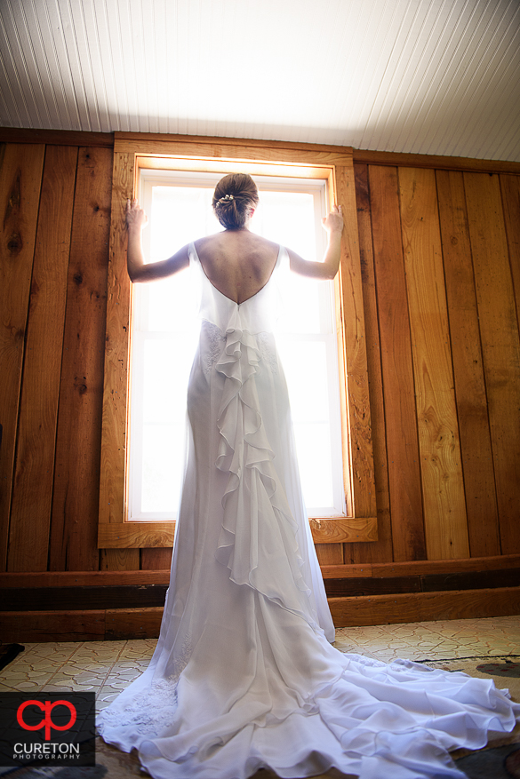 Beautiful bride standing in window light.