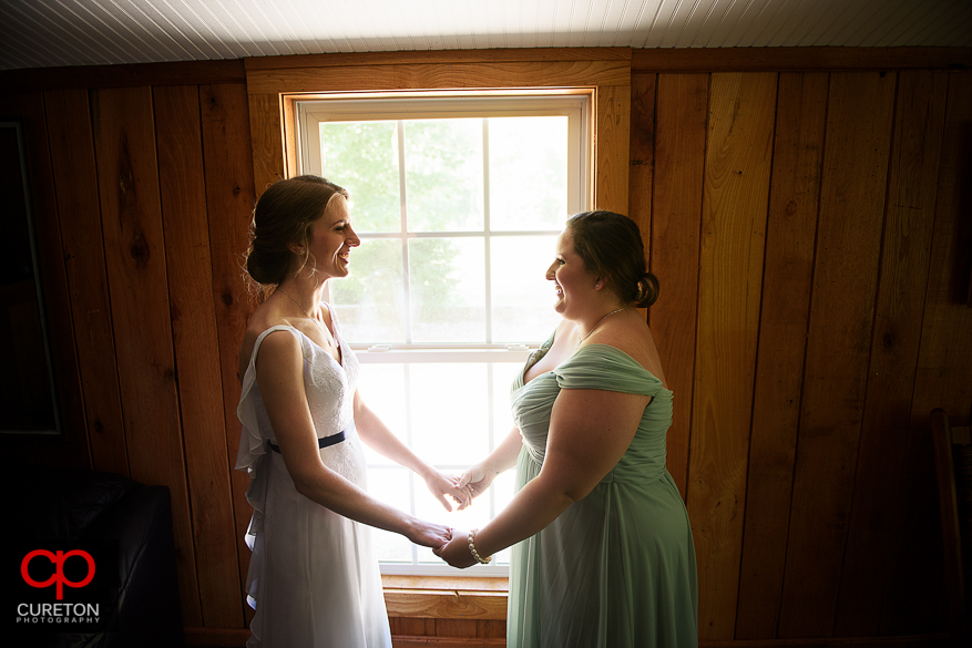 The bride and her bridesmaid share a moment before her Timberock at Hopkins Farm wedding in Simpsonville,SC.