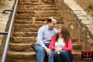 Couple sitting on the steps in Falls Park during an engagement session.