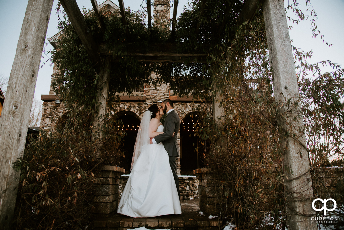 Bride and groom under a pergola at their wedding at The Arbors in Cleveland NC.